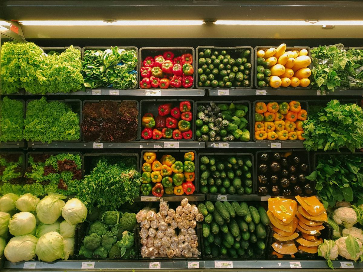Supermarket produce shelves stocked with fresh fruit and vegetables